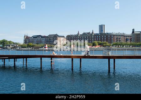 Copenhagen, Denmark - 02 Sep 2021: Young people sunbathing in the city centre and old couple walking, at Kalvebod Wave, Kalvebod Brygge Stock Photo