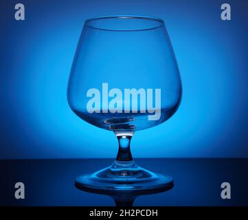 transparent glass goblet on the blue background Stock Photo