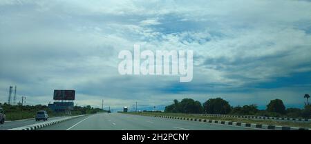 Long asphalt road under the cloudy rainy sky Stock Photo - Alamy