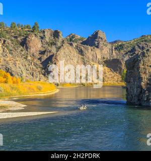 floaters fishing below cliffs and fall colors along the missouri river near dearborn, montana Stock Photo