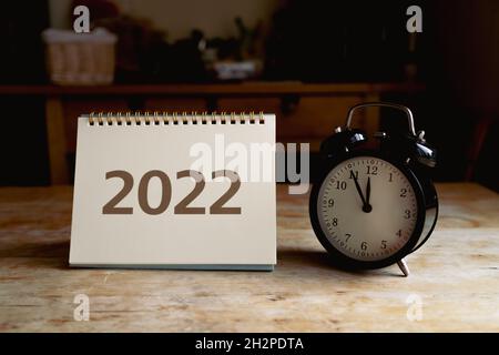 2022 calendar and black vintage clock on wooden table Stock Photo
