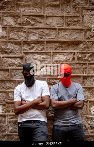 Two afro young men in ski masks in alleyway Stock Photo