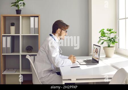 Doctor having online consultation with patient via video call on laptop computer Stock Photo