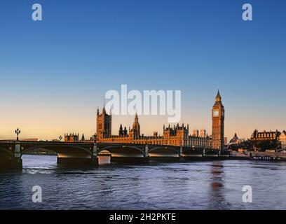 Houses of Parliament illuminated by first light sunrise River Thames at high tide from South Bank London UK Stock Photo