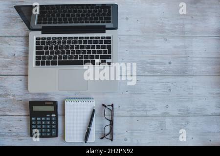 workplace, business and economy finance background, flatlay of laptop computer, calculator and notepad on wooden desk Stock Photo