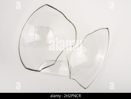 Broken glass pieces on white background. Close up, top view. Stock Photo