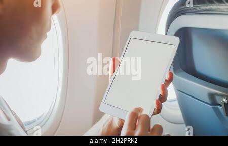 passenger using digital tablet computer in airplane,  wifi internet access on the plane, banking or reading email on screen Stock Photo