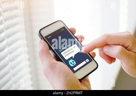 chatbot online, AI robot assistant help on website on screen of smartphone in hands Stock Photo