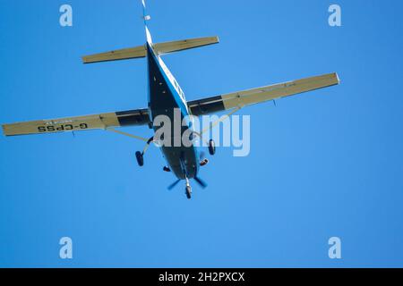 cose up of Cessna 208b Grand Caravan G-CPSS light aircraft flies low over head just after taking off with parachutists on board Stock Photo