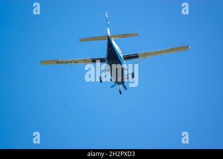 cose up of Cessna 208b Grand Caravan G-CPSS light aircraft flies low over head just after taking off with parachutists on board Stock Photo