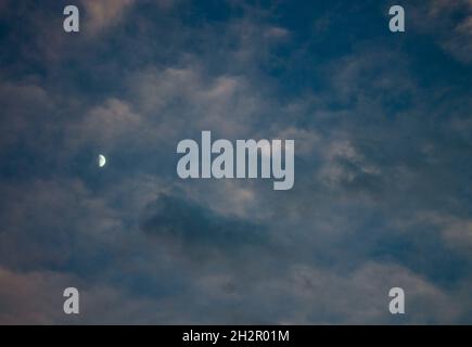 moon and clouds against blue sky Stock Photo