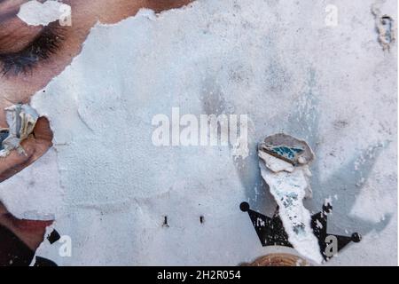 Grunge ripped torn collage posters creased crumpled paper placard texture background. Old abandoned posters on the wall in the city Stock Photo