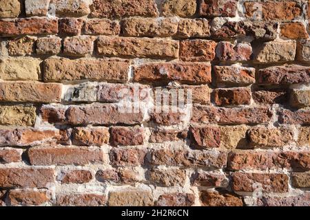 Old, vintage orange brick wall texture. Damaged half broken bricks, aged broken mortar. Flat lay, top view background. Stock Photo
