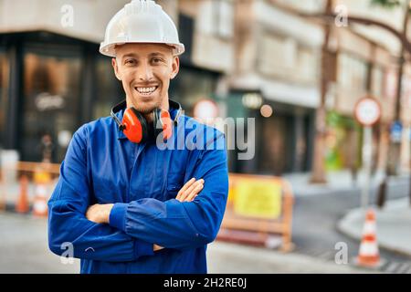 Young caucasian worker smiling happy wearing uniform at the city. Stock Photo