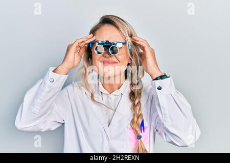 Beautiful young blonde woman wearing optometry glasses with hand on head, headache because stress. suffering migraine. Stock Photo