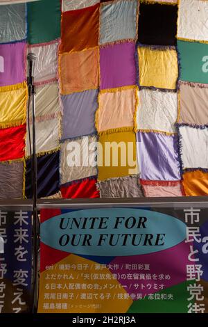 Tokyo, Japan. 23rd Oct, 2021. A microphone and a patchwork backdrop seen at the Unite For Our Future event in Shinjuku.In an effort to unseat the ruling LDP (Liberal Democratic Party) in the October 31st Lower House election called by Japan's new Prime Minister, Fumio Kishida, the main, left-leaning opposition parties have decided to campaign together and not field candidates against each other. (Photo by Damon Coulter/SOPA Images/Sipa USA) Credit: Sipa USA/Alamy Live News Stock Photo