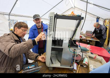 Walporzheim, Germany. 21st Oct, 2021. The two "Elektroseelsorger" Thomas (l) and Iwer repair a construction dryer in the workshop tent. The donation-funded and volunteer-based association "Elektroseelsorge(r)" consists of around 220 electricians, telecommunications technicians and other volunteers from all over Germany. They get muddy and once sodden electrical appliances such as drills, cordless screwdrivers, kitchen machines and heaters working again. (To dpa: ""Elektroseelsorge(r)" in the Ahr Valley: "Festival of Lights" as a sign of hope") Credit: Thomas Frey/dpa/Ģ����ý Live News Stock Photo