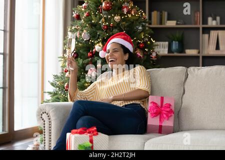 Happy young african woman celebrating Christmas at home. Stock Photo