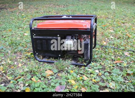 Gasoline Portable Generator. Close up on Mobile Backup Generator in the garden. Standby Generator - Outdoor Power Equipment Stock Photo