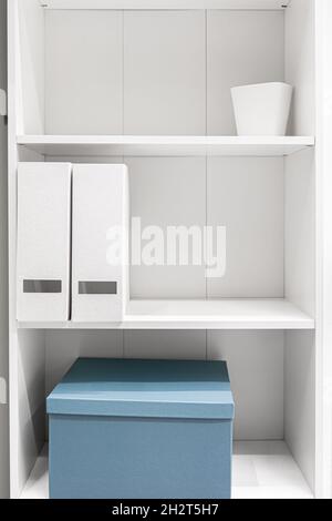 A minimalist wardrobe, half-empty shelves in a white wardrobe. Stock Photo