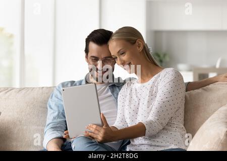 Happy young family couple using digital computer tablet. Stock Photo