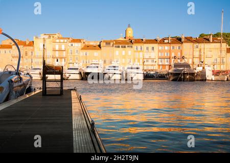 Saint Tropez - France  Vue sur le port de Saint Tropez, avec ses bateaux, ses appartements et son église. Photo prise pendant le coucher du soleil.  - Stock Photo