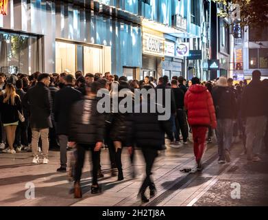 23 October 2021, Hessen, Frankfurt/Main: People walk past a long line of waiting people on the night of Sunday, Oct. 24, 2021 on the Zeil in front of the entrance to the club 'Gibson' in the city center. Since mid-September 2021, clubs and discos in Hesse are allowed to reopen their doors. Mask obligation, distance bans or person limitations do not have to be considered thereby. The only condition: the visitors are vaccinated or recovered. (to dpa 'Maskless through the night until a new day awakens') Photo: Frank Rumpenhorst/dpa Stock Photo