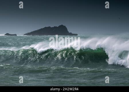 Wild waves breaking and choppy sea around The Goose Island off the Pentire Point East headland in Fistral Bay in Newquay in Cornwall. Stock Photo