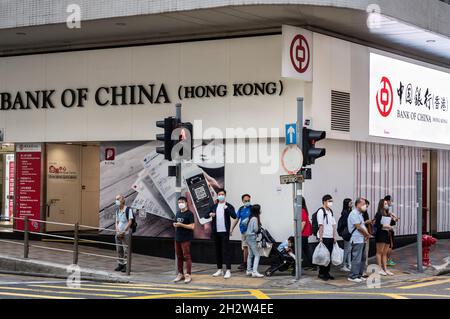 Hong Kong, China. 18th Oct, 2021. Pedestrians wait at a traffic light in front of the Chinese state-owned commercial banking company Bank of China branch in Hong Kong. (Credit Image: © Budrul Chukrut/SOPA Images via ZUMA Press Wire) Stock Photo