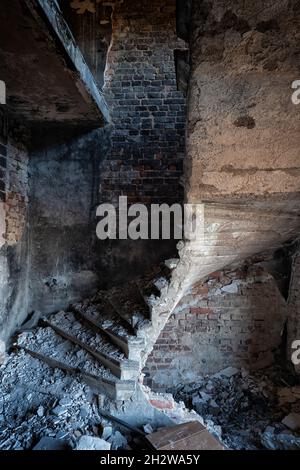 Spiral stairs in abandoned manor house spooky interior, urban exploration. Stock Photo
