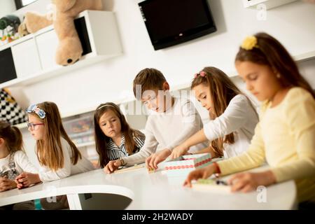 Group of little kids playing with preschool wooden educational toys Stock Photo