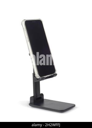 Smartphone with blank screen on black plastic holder isolated on white background Stock Photo