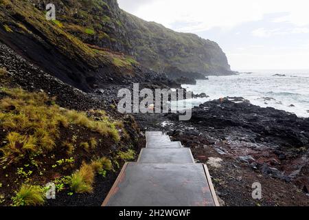 Steps leading to the hot spring at volcanic lava formations on the coast at Ferraria, Sao Miguel island, Azores, Portugal Stock Photo