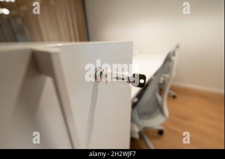 Close up drawer with locking mechanism on which the key is, located in a modern office in the company Stock Photo