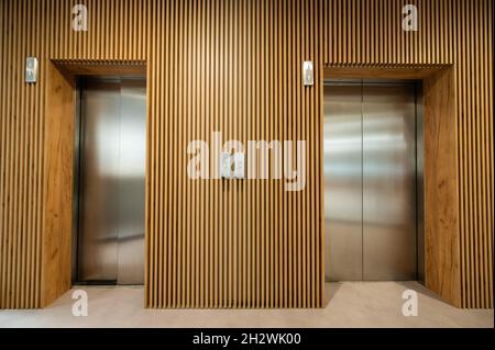 Two modern elevators in a large world corporation Stock Photo