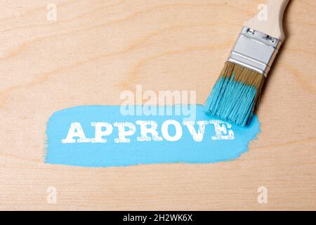 APPROVE. Blue color with a paint brush on a wooden background. Stock Photo