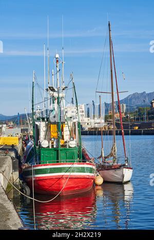 A fishing boat and a sailboat moored in the Port of Pasajes. Gipuzkoa, Spain.