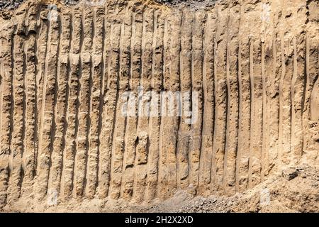 Excavator bucket footprints. Excavator furrows. Stripes from work of heavy quarry equipment. Furrow closeup from the excavator on earth as background Stock Photo