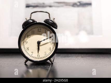 Close-up of a vintage alarm clock on a blurred background. Stock Photo