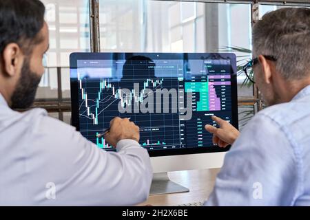 Two traders brokers stock exchange investors analyzing crypto trading charts. Stock Photo