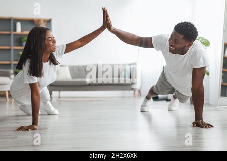 Young black couple planking and giving high five Stock Photo