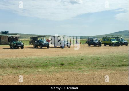 A row of 4x4 vehicles waiting for incoming tourists arriving at Keekorok airstrip, Masai Mara, Kenya Stock Photo