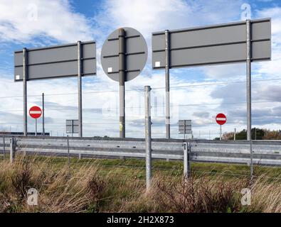 No entry and direction road signs above the barrier of a motorway junction in the UK Stock Photo