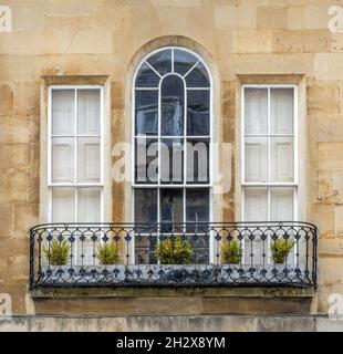 Elegant Georgian triple-sash window with arched central window fronted by a wrought iron balcony - Bath Somerset UK Stock Photo