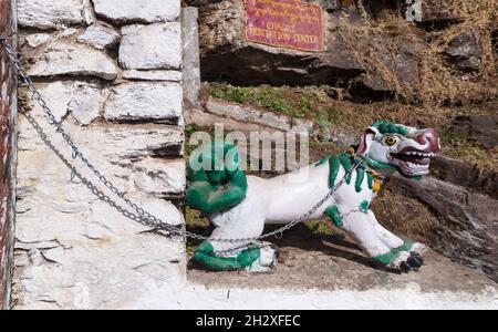 The figure of a fantastic dragon dog on the chain at the entrance to the Chagri Cheri Dorjeden Monastery, Buddhist monastery near capital Thimphu in B Stock Photo