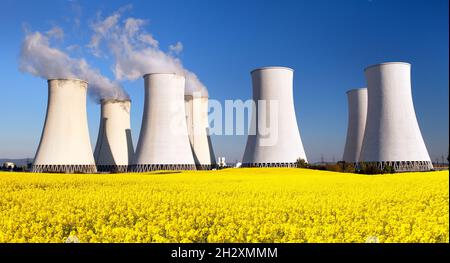 Panoramic view of Nuclear power plant Jaslovske Bohunice with golden flowering field of rapeseed, canola or colza - Slovakia - two possibility for pro Stock Photo