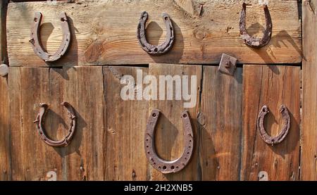 Old horseshoes on a wooden door in the village Stock Photo