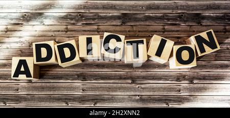The word addiction made of wooden letters lies on a brown background Stock Photo