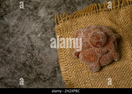 Sweet bread called Bread of the Dead (Pan de Muerto) on the brown sacking Stock Photo