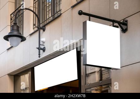 Mock up. Blank white rectangular shape signboard on the wall and above entrance outdoors. Signage of shop, store, cafe, restaurant Stock Photo